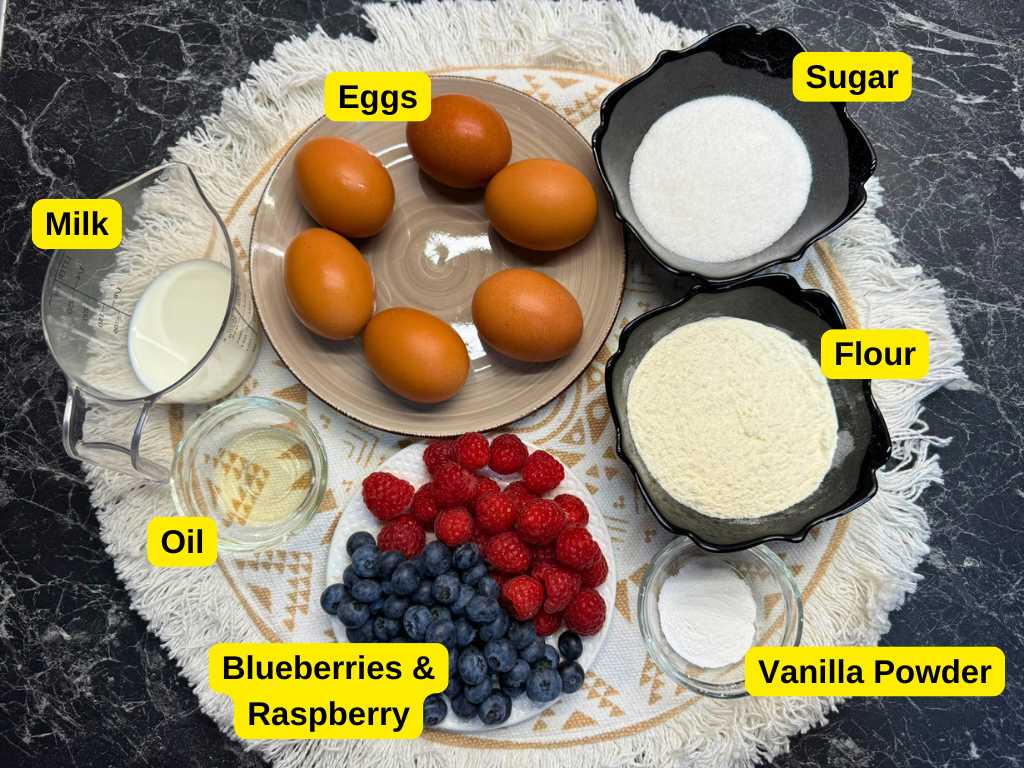 Ingredients for fluffy pancakes including eggs, flour, sugar, milk, oil, vanilla powder, blueberries, and raspberries arranged on a table