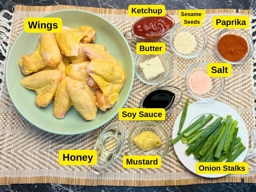 Ingredients for honey soy chicken wings including chicken wings, ketchup, soy sauce, mustard, honey, butter, paprika, sesame seeds, salt, and green onions