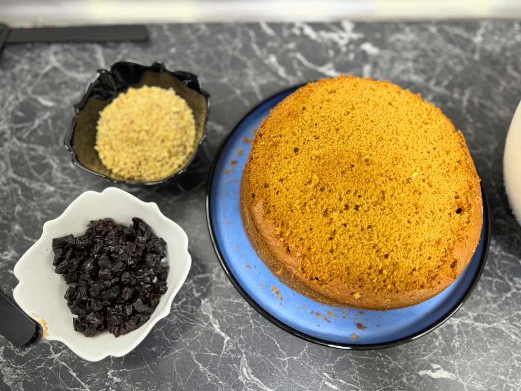 Baked honey bun cake layer with chopped walnuts and dried plums for Russian honey cake assembly