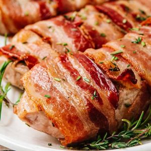 Wrapped in crispy bacon, these juicy, herbaceous Bacon Wrapped Pork Chops are so easy to make in your oven! A couple of simple secrets in this easy recipe guarantee perfect results every time. Perfect date night or dinner party main course.