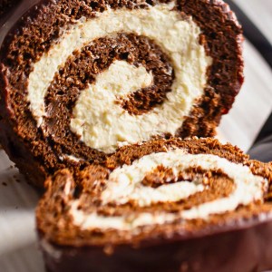 Easy no-bake coconut dessert roll with creamy coconut filling and chocolate biscuit dough, sliced into swirls