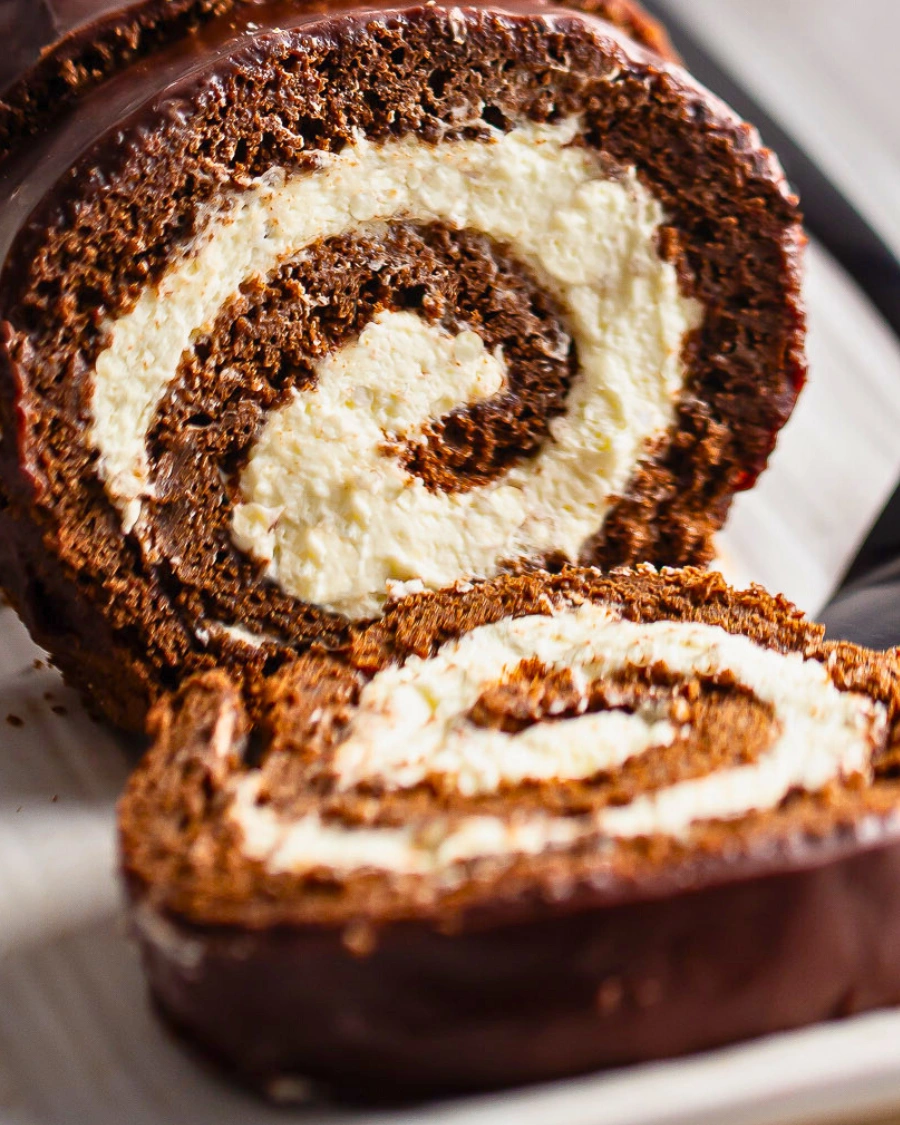 Easy no-bake coconut dessert roll with creamy coconut filling and chocolate biscuit dough, sliced into swirls