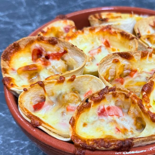 Cheesy chicken quesadilla cones baked with melted cheddar and red peppers in a tortilla cup