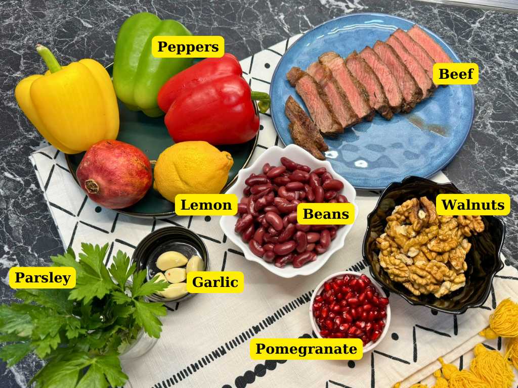 ingredients for Tbilisi salad including beef, kidney beans, bell peppers, walnuts, pomegranate, garlic, parsley, and lemon
