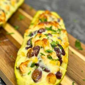 Close-up of baked stuffed zucchini boat with chicken, beans, corn, and melted cheese – recipe stuffed zucchini boats