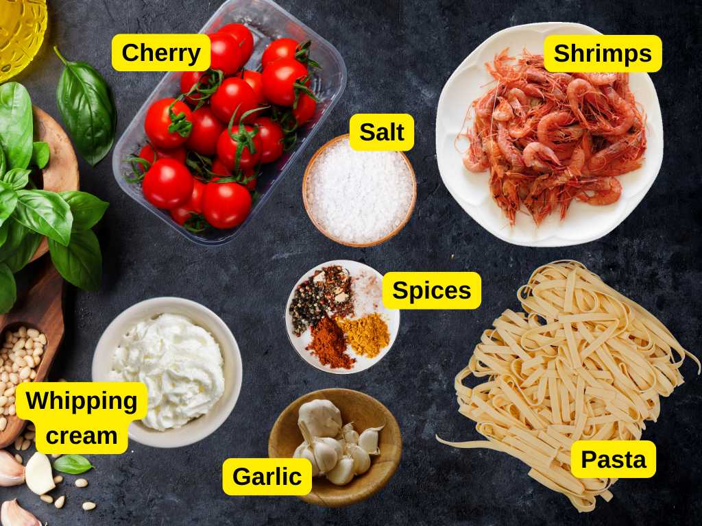 Flat lay of labeled ingredients for creamy shrimp pasta, including cherry tomatoes, shrimp, garlic, whipping cream, pasta, salt, and spices on a dark surface