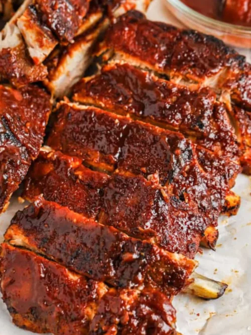 Sliced pork ribs with a glossy reddish-brown glaze resting on parchment paper.