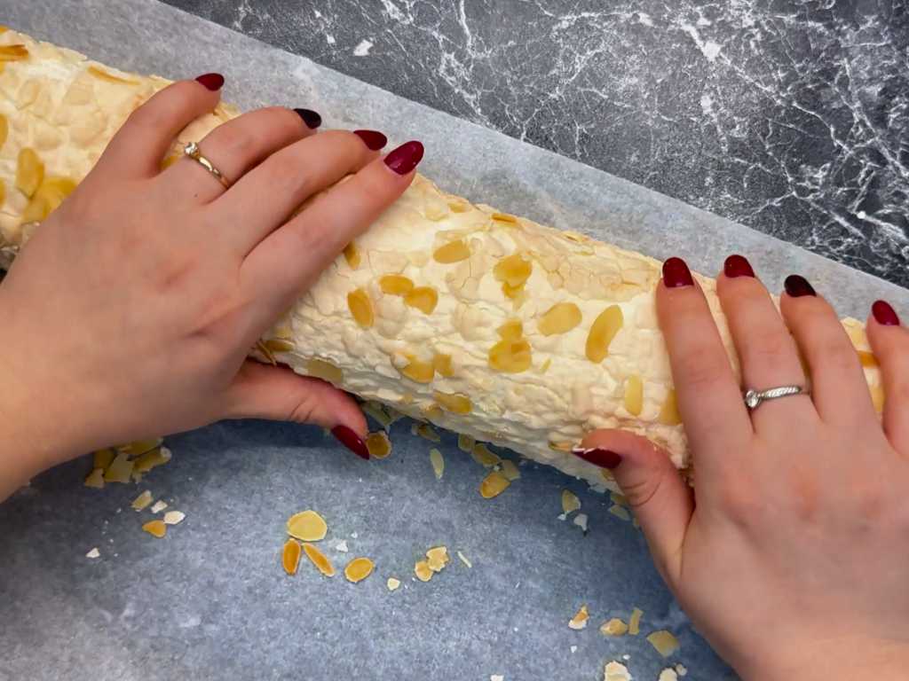 Rolling mandarin meringue roll filled with cream and mandarin curd