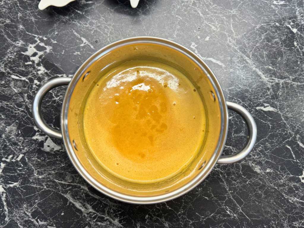 Mandarin curd cooking in a saucepan for mandarin meringue roll