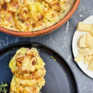 Creamy au gratin potatoes made with thinly sliced yellow potatoes, bacon, roasted garlic, heavy cream, and a blend of Gruyere, classic cheese, and Parmesan, baked until golden and bubbly