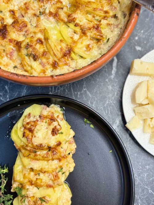 Creamy au gratin potatoes made with thinly sliced yellow potatoes, bacon, roasted garlic, heavy cream, and a blend of Gruyere, classic cheese, and Parmesan, baked until golden and bubbly