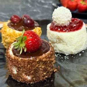 Mini Mason Jar Pudding Snack in a plate topped with fruits and chocolate.