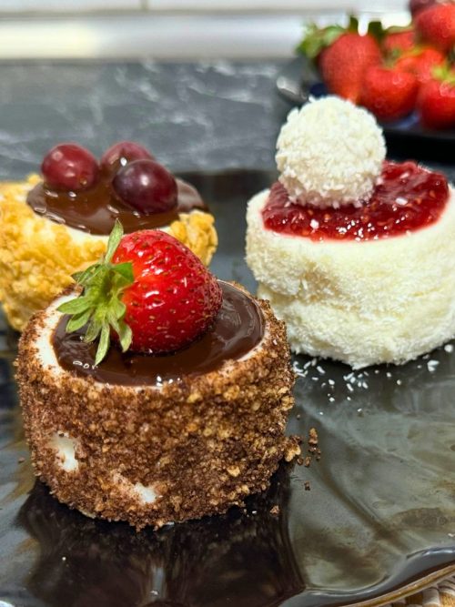 Mini Mason Jar Pudding Snack in a plate topped with fruits and chocolate.