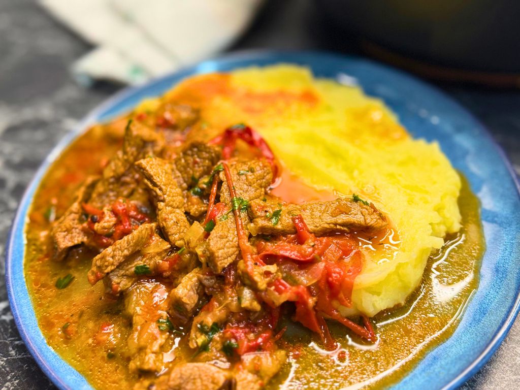 A plate of Tender Skillet Beef Stew and mashed potatoes
