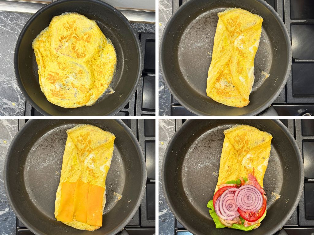Egg wrap in a pan folded around burger buns, then layered with cheddar cheese, bacon, lettuce, tomato, and red onion slices.