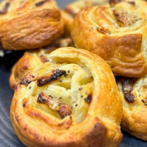Close-up of freshly baked banana puff pastry rolls with golden flaky layers
