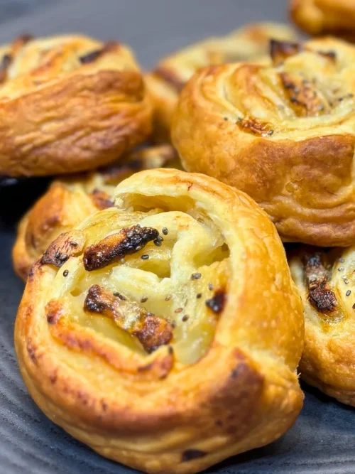 Close-up of freshly baked banana puff pastry rolls with golden flaky layers