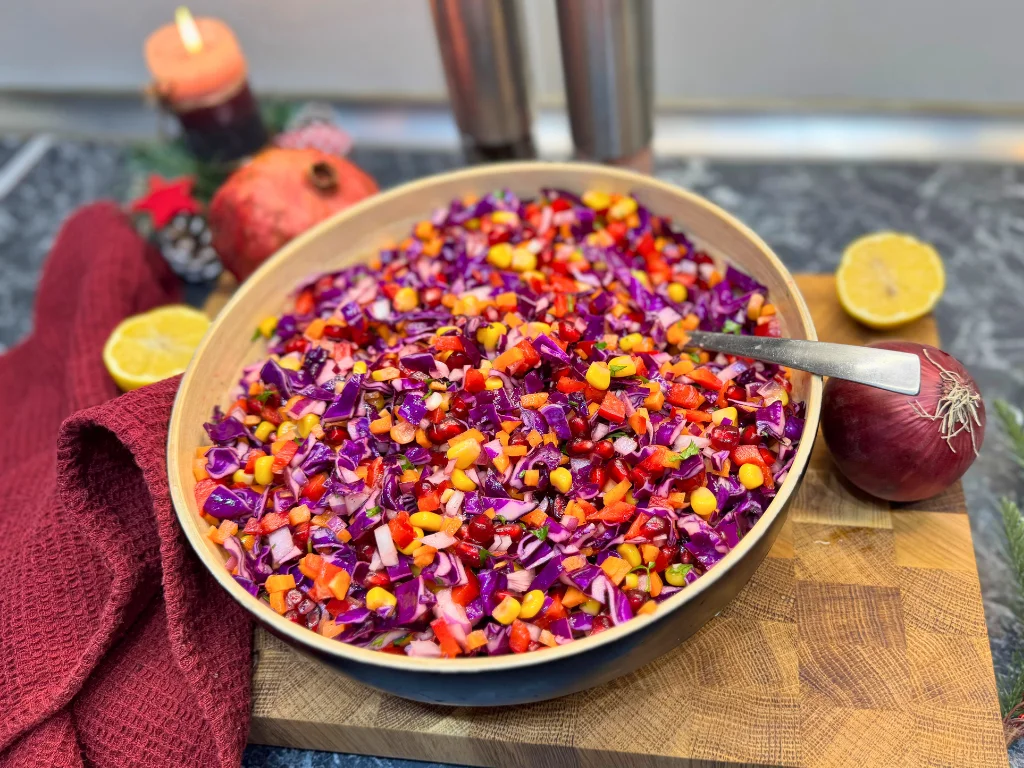 Antioxidant raw vegetable salad with red cabbage, pomegranate, corn, carrots, and lemon sumac dressing served in a bowl