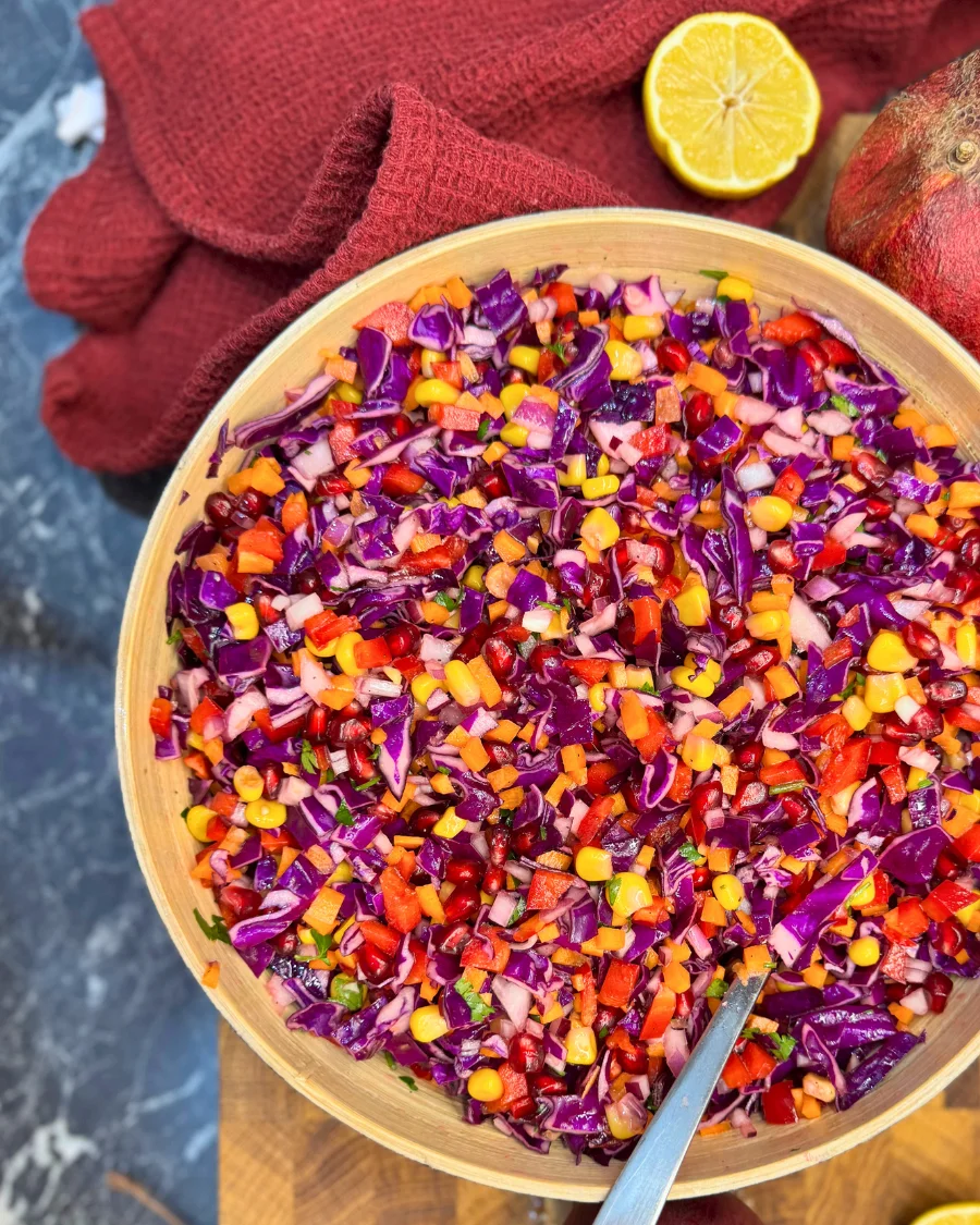Antioxidant raw vegetable salad with red cabbage, pomegranate, corn, and carrots