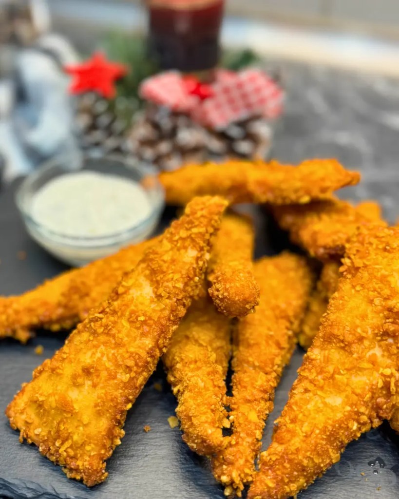 Crispy Chicken Tortilla Bites arranged on a slate board with dipping sauce, golden and perfectly fried.