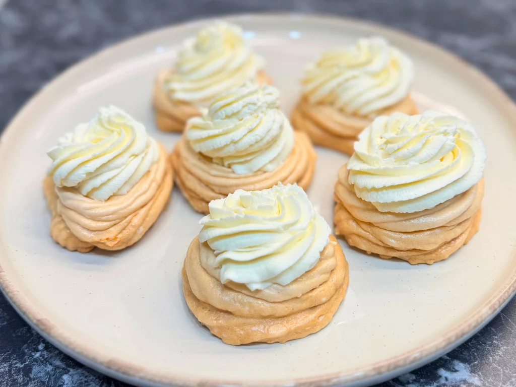 Individual mini pavlovas with crisp meringue shells and a swirl of mascarpone cream.