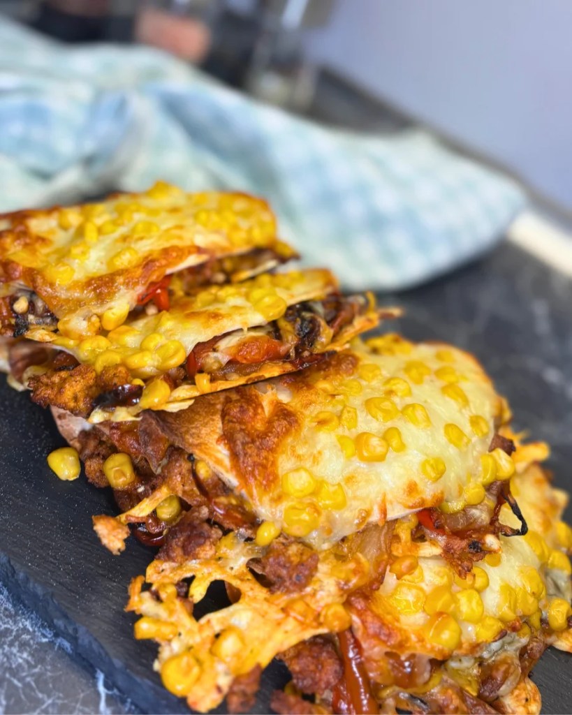 stack of cheesy baked chicken tacos with ground chicken and roasted vegetables