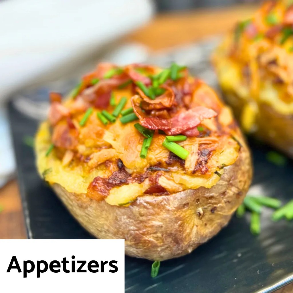 baked stuffed potato appetizer topped with cheese, bacon, and chives on a plate