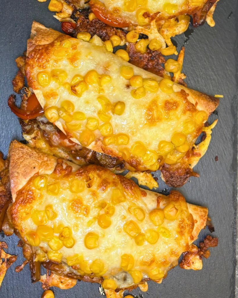 easy crispy oven baked chicken tacos topped with melted cheese and corn