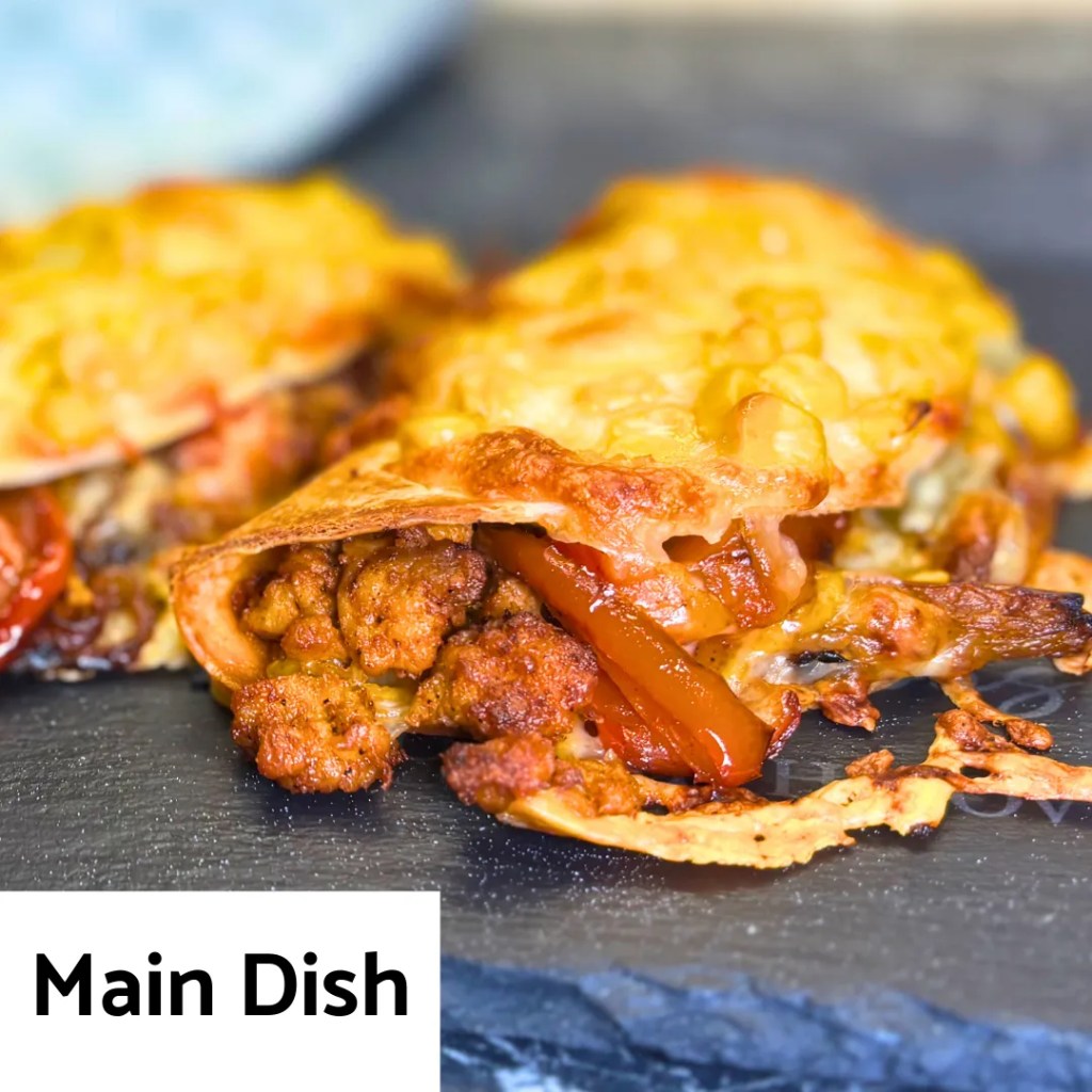 crispy baked chicken tacos with melted cheese and peppers served as a main course