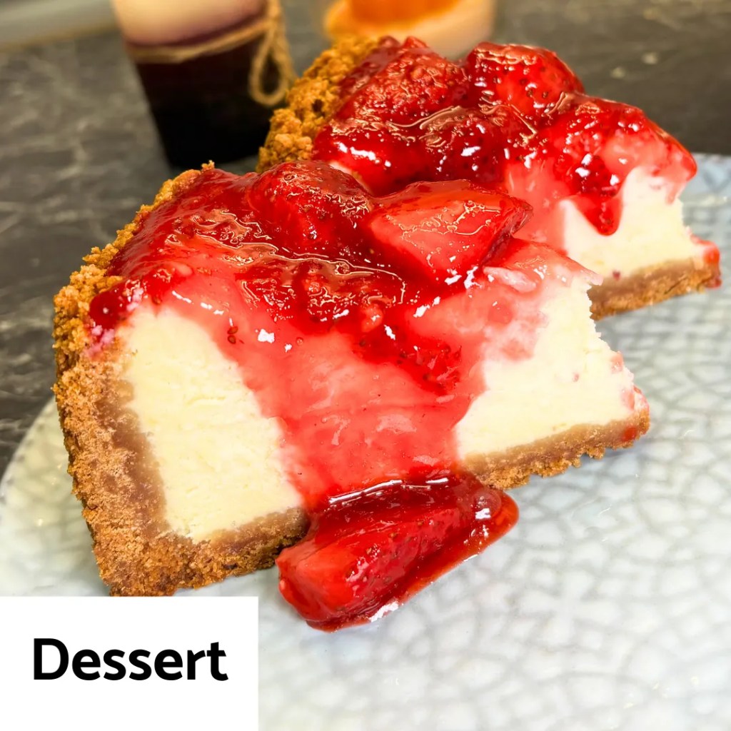 slice of creamy cheesecake topped with fresh strawberry sauce on a plate