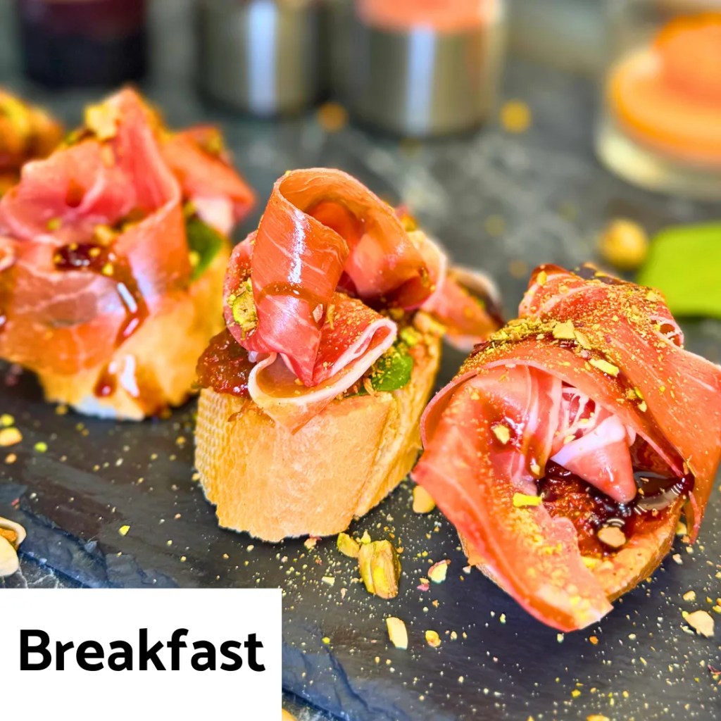 crispy toasted bread topped with prosciutto and pistachios served as a breakfast recipe