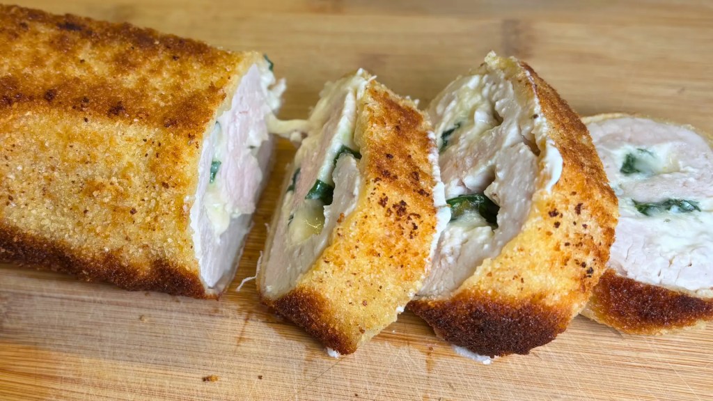 Crispy stuffed turkey roulade sliced showing creamy cheese filling