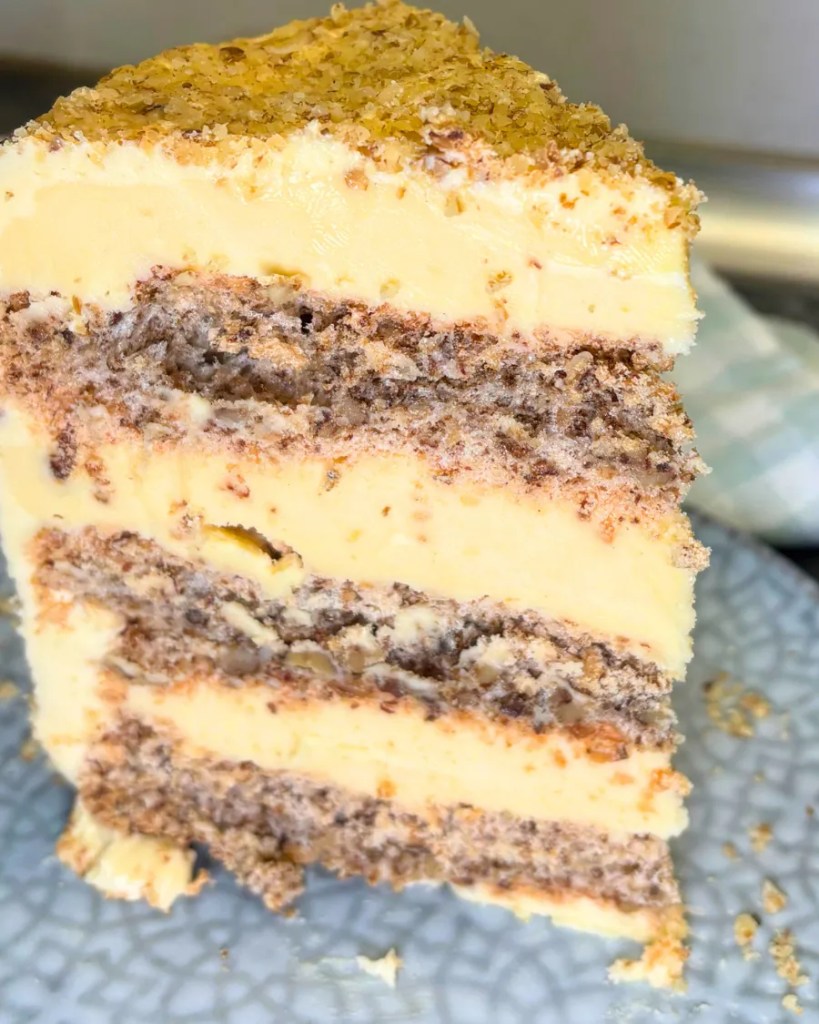 Soft creamy Kyiv cake slice with crunchy hazelnut meringue layers