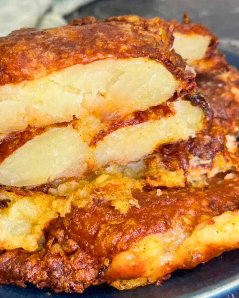Close-up of crispy smashed potatoes with melted cheese and soft fluffy potato inside