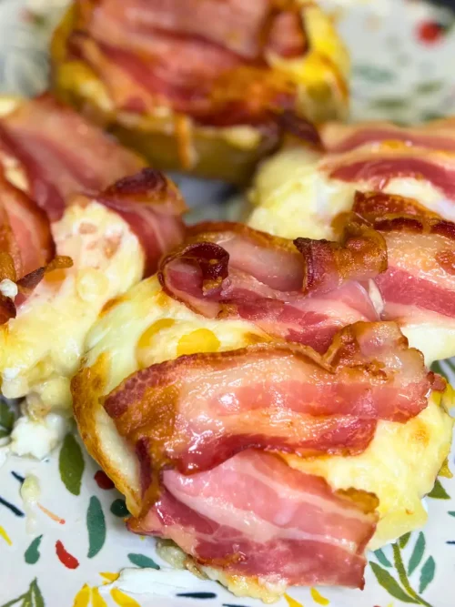 Homemade cheesy potato boats with bacon and baked eggs served on a decorative plate.