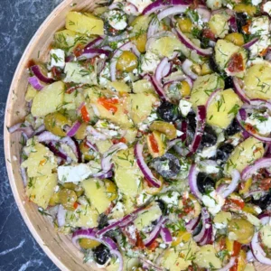 Close up of Mediterranean potato feta salad with olives, red onion, dill, and sun dried tomatoes.