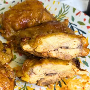 Juicy honey mustard baked chicken thighs sliced open to show the tender and moist meat inside.