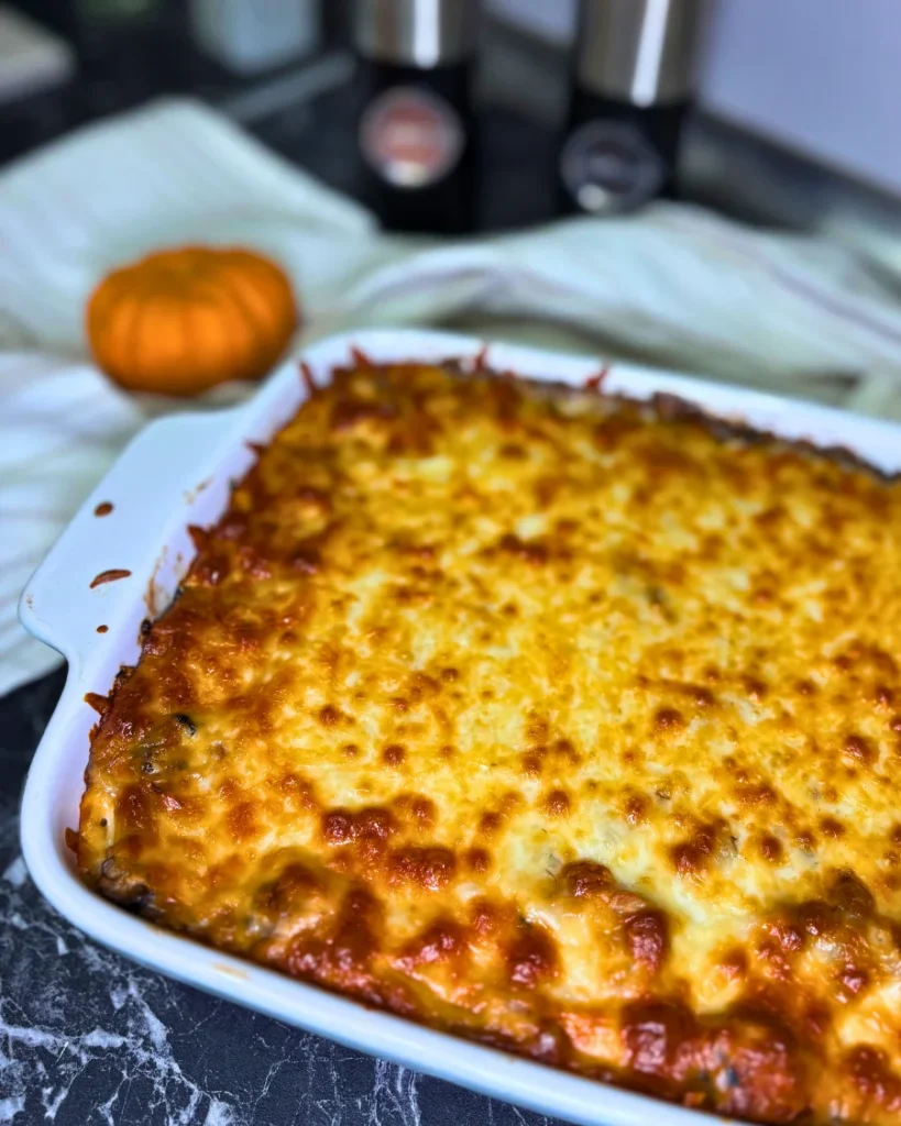 Homemade chicken and mushroom potato casserole topped with melted, golden mozzarella in a white rectangular baking dish.